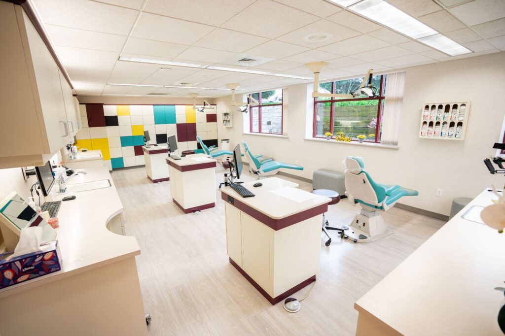 Modern orthodontic treatment area at Kittleson Orthodontics in Mequon, featuring comfortable treatment chairs, digital equipment, and a colorful accent wall, emphasizing a welcoming environment for patients of all ages seeking braces and orthodontic care.