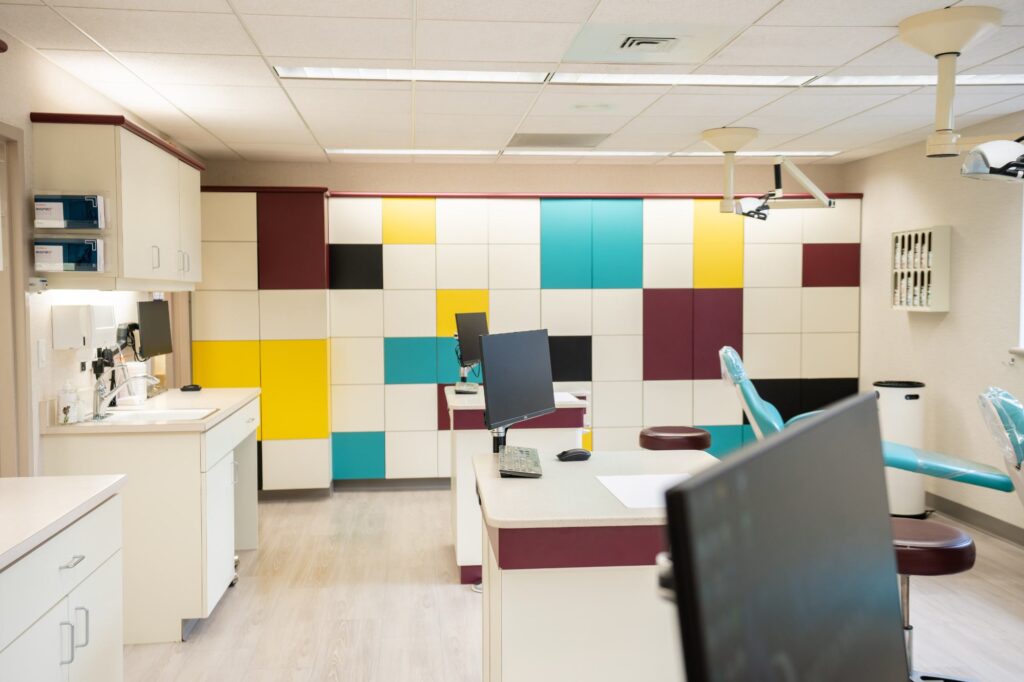 Modern orthodontic treatment area at Kittleson Orthodontics in Mequon, featuring colorful cabinetry, treatment chairs, and advanced technology for patient comfort and care.