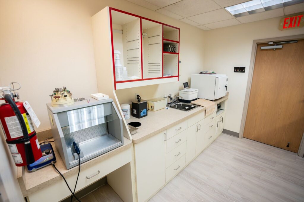 Modern orthodontic treatment area in Kittleson Orthodontics Mequon, featuring sterilization equipment, a sink, and organized storage, emphasizing clean and safe orthodontics for patients.