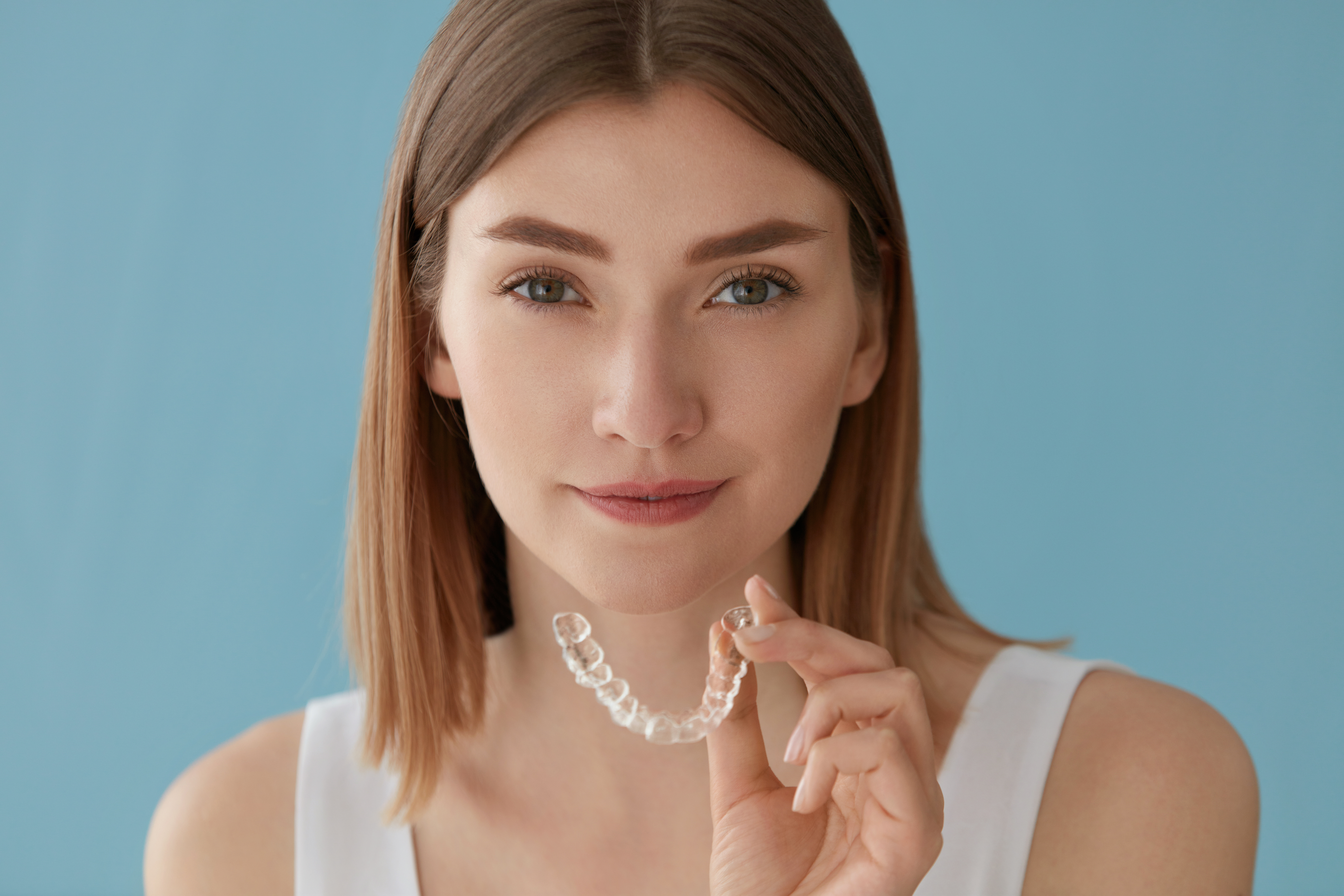 Woman holding clear aligners for orthodontic treatment in Mequon at Kittleson Orthodontics