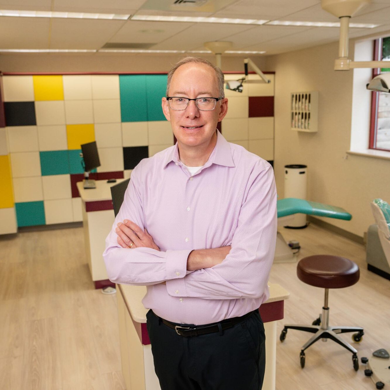 Dr. John Kittleson, board-certified Mequon orthodontist, standing confidently in modern orthodontic office, showcasing commitment to patient care and beautiful smiles at Kittleson Orthodontics.